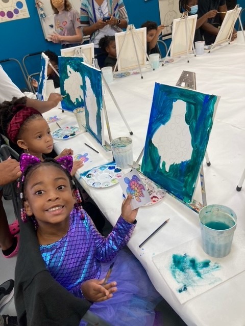 Children making prints at the Children's Art Classes of Cary table at the Fenton Art Festival